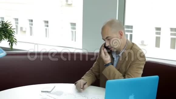 两个商人坐在一家咖啡馆的笔记本电脑前服务员带他们去吃午餐面条和咖啡商务午餐视频的预览图