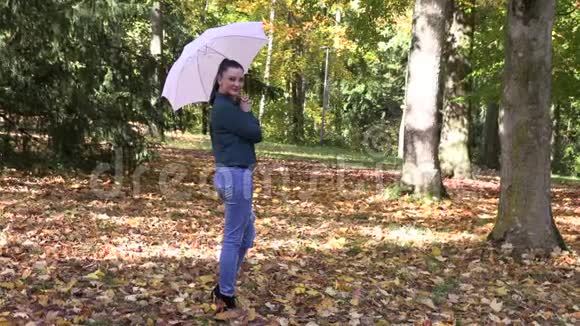 秋公园里一个长着一把伞的深褐色美女视频的预览图