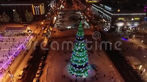 市中心的圣诞树附近的冰场夜晚的灯光视频的预览图