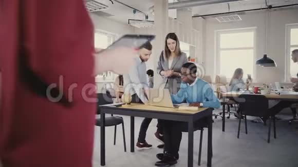 自信的女性CEO帮助混合种族的男性同事看着笔记本电脑屏幕现代办公室4K的团队合作视频的预览图