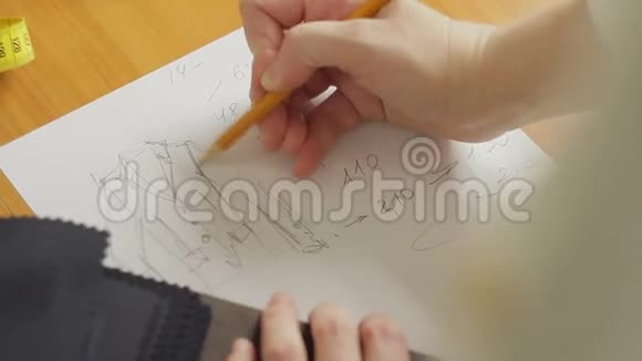 一个女人的手特写一个时装设计师在阁楼上画衣服的草图视频的预览图