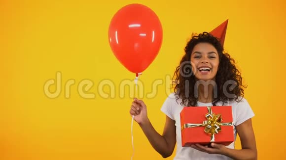 快乐的混血女孩拿着礼品盒和气球庆祝生日聚会视频的预览图