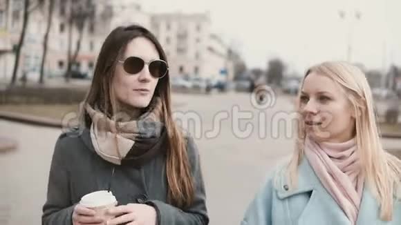 两个白人女人在街上聊天女朋友在冬天阳光明媚的日子里一起散步朋友分享时间视频的预览图