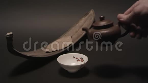 将中国茶从传统的宜兴陶壶中倒入一杯视频的预览图