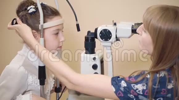 女眼科医生正在给小女孩做生物显微镜检查视频的预览图
