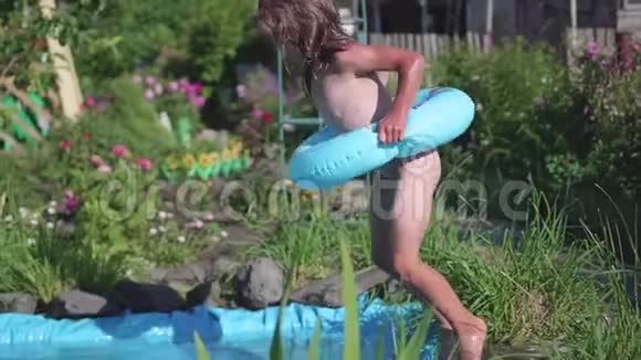 一个小女孩跳进一个小池塘从跳跃中溅起水来在炎热的炎热的夏日里孩子喜欢喝凉水视频的预览图