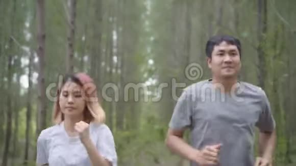 健康的年轻运动运动员亚洲运动员穿着运动服装在森林小径上跑步和慢跑视频的预览图