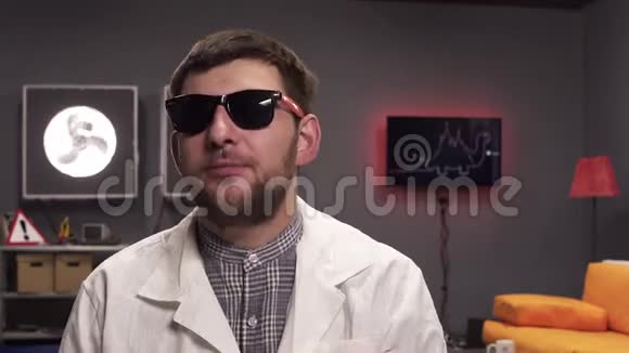 有胡子的科学家戴着太阳镜和白色的实验室外套解释事情视频的预览图