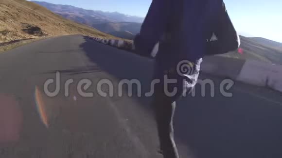 年轻穆斯林妇女戴着头巾在山路上奔跑阳光灿烂后视视频的预览图
