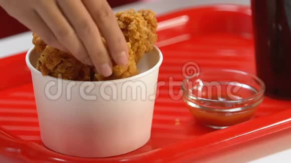 女士用手蘸脂肪脆鸡腿蘸番茄酱快餐视频的预览图