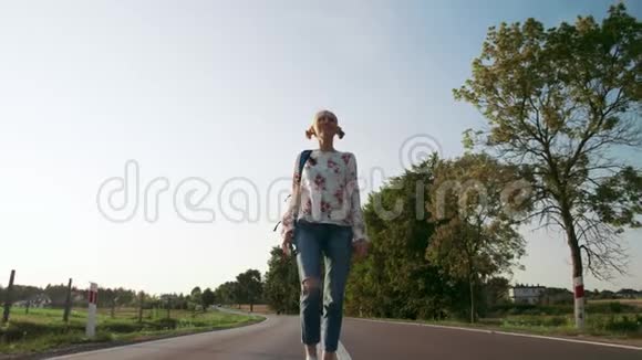带背包的女人在乡间的路上行走视频的预览图