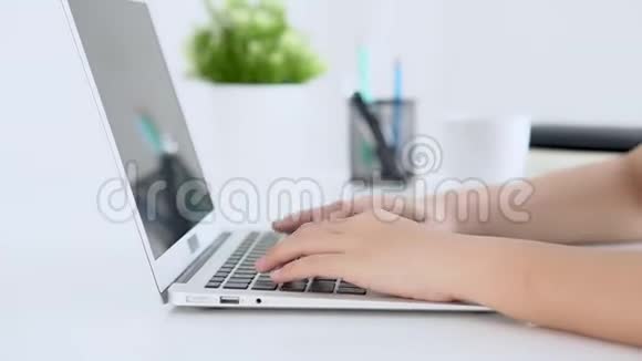 特写自由职业妇女微笑着在办公桌办公室的笔记本电脑上工作和打字配有专业人员视频的预览图