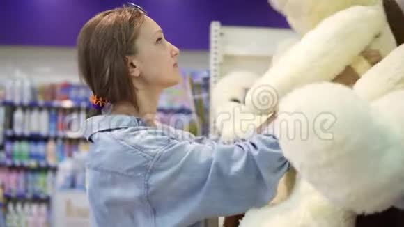 关闭女孩在超市货架上寻找软玩具的镜头她决定做出选择视频的预览图