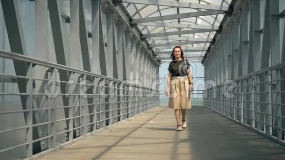 一个穿着裙子的美女正在人行天桥上散步背着背包的女人视频的预览图