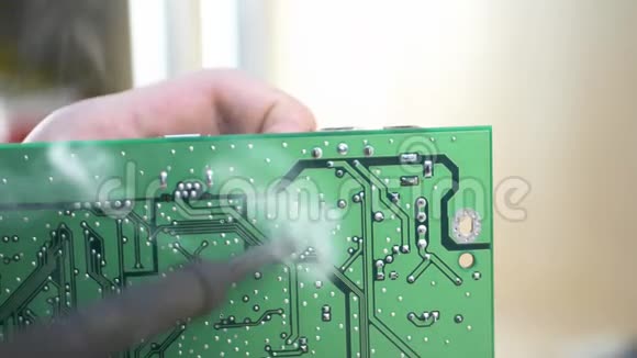 年轻电脑技师焊接绿色主板视频的预览图