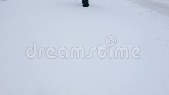 一个穿红裤子的小女孩走过白雪皑皑的雪堆视频的预览图