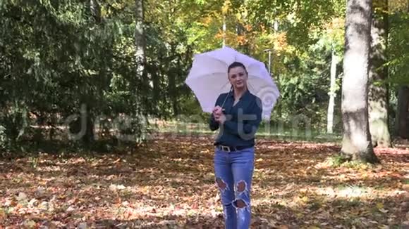 秋公园里一个长着一把伞的深褐色美女视频的预览图