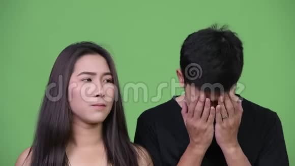 年轻的亚洲女人年轻的亚洲男人捂着脸视频的预览图
