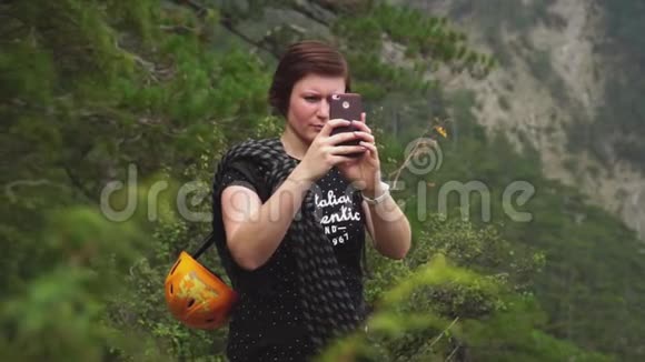 女士旅游在智能手机上拍摄美丽的绿色森林和山脉自然景观视频的预览图