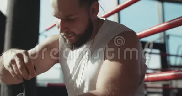 拳击手在拳击训练前用黑色手包裹手视频的预览图