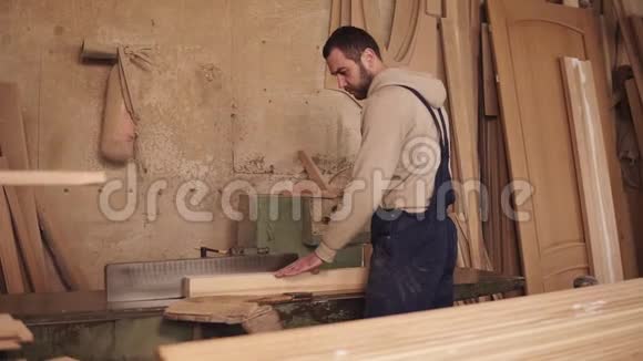 木匠把圆锯上木块的两侧剪开木制刨花车间里满是视频的预览图