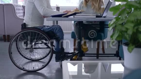 残疾学生患病学生坐轮椅的高年级男子和辅导妇女在家庭教学课程中接受教育视频的预览图