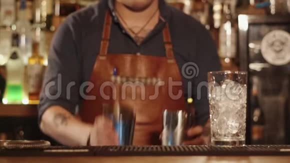 酒保双手熟练地将杯子里的液体倒入另一个杯子视频的预览图