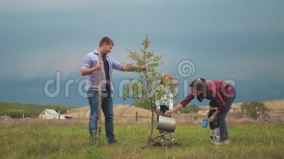 友好的家庭孩子在花园里和父母一起植树视频的预览图