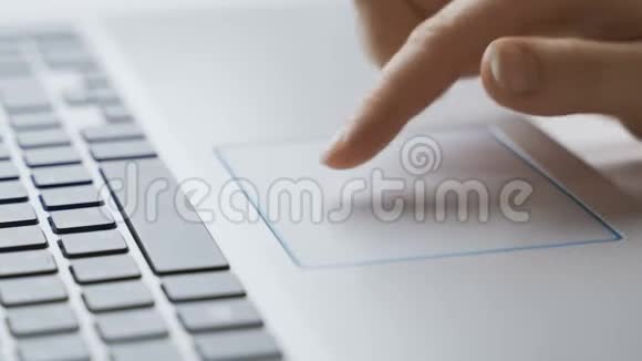 特写手指触摸笔记本电脑触摸板在线搜索信息和滚动网站视频的预览图
