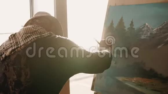 老孤独的画家在他的画室里画了一幅风景画视频的预览图