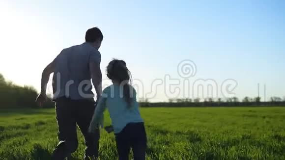 快乐的父母父亲正在花时间和两个孩子在一起女孩们和他爸爸在草地上奔跑触摸和奔跑视频的预览图