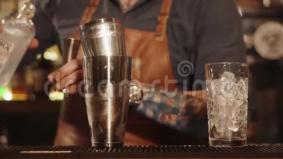 酒保的手紧紧一个人把伏特加倒入量杯中视频的预览图