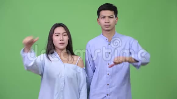 年轻的愤怒的亚洲商务夫妇一起竖起大拇指视频的预览图