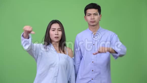 年轻悲伤的亚洲商务夫妇一起竖起大拇指视频的预览图