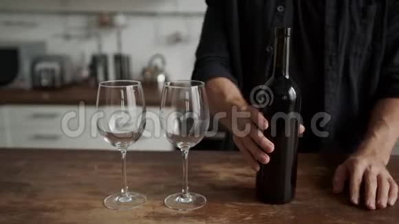 厨房里的一个年轻人把酒倒进杯子里浪漫的约会筹备会议视频的预览图