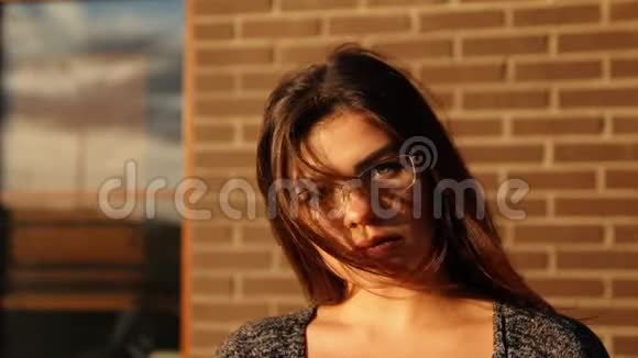 一位戴眼镜的女商人的慢镜头肖像纠正在风中飘扬的头发背景是视频的预览图