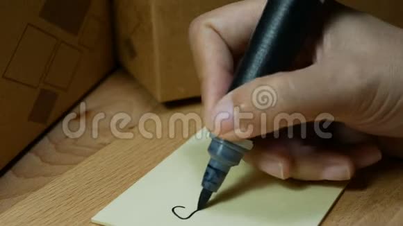 4K镜头女性用黑色魔笔在记事本上手写单词并将便条贴在投递箱上视频的预览图