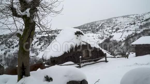 一座被雪覆盖的乡间小屋前的道视频的预览图