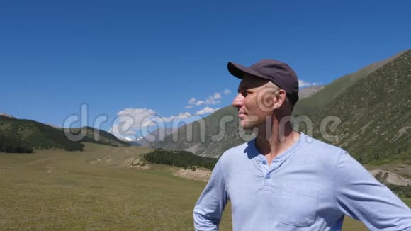 欣赏山景和呼吸山谷新鲜空气的成年男子视频的预览图