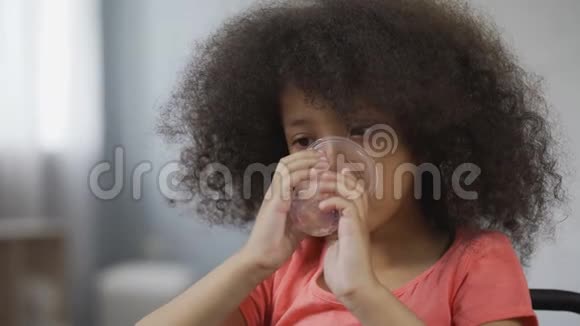 口渴的非裔美国儿童仍然喝矿泉水特写儿童的脸视频的预览图