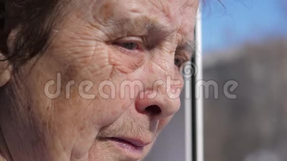 一位因颤抖的眼睑而痛苦的老妇人悲伤的面容特写视频的预览图