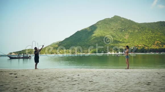 男孩和女孩在海滩上玩山的背景视频的预览图