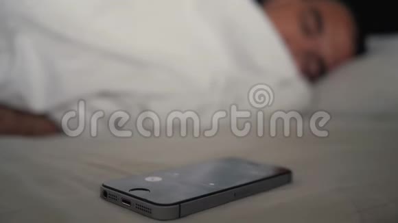 年轻人睡在床上手机显示器上有闹钟现代技术视频的预览图