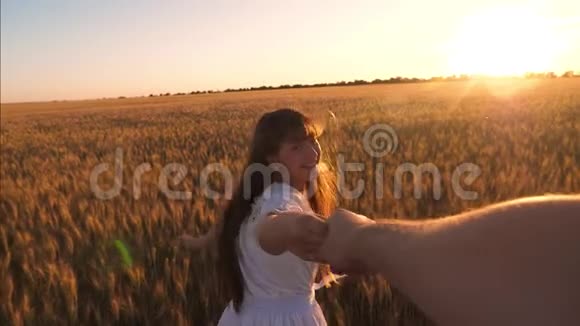 年轻的幸福夫妇在日落时分穿过一片黄麦地幸福的女孩笑着慢动作视频的预览图