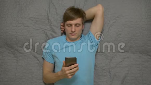 年轻人躺在床上打电话视频的预览图
