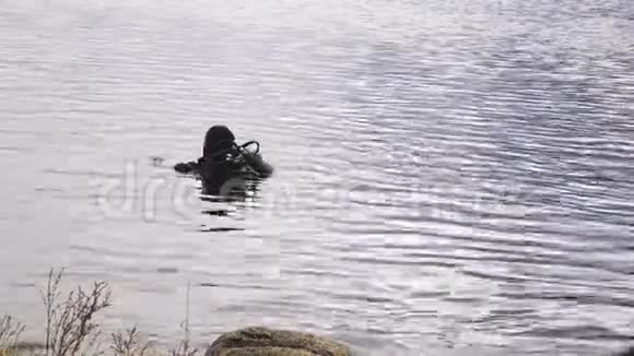 潜水员进入山湖水为紧急救援人员练习技术浸泡在冷水中视频的预览图