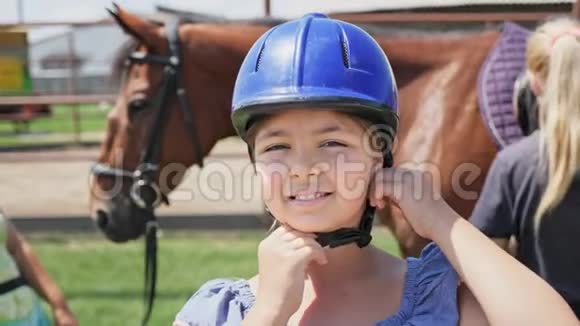 以马为背景的戴头盔的漂亮女孩的肖像视频的预览图