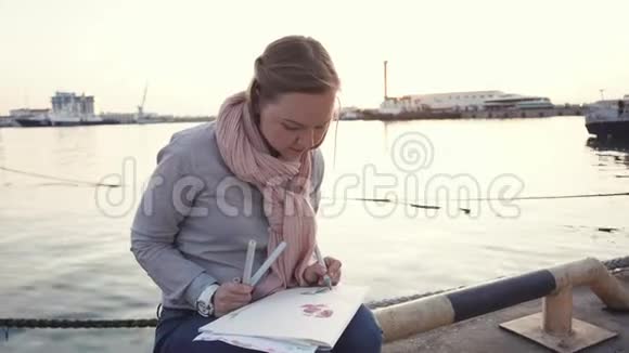 一个年轻的女人来到港口是为了独自一人画画视频的预览图