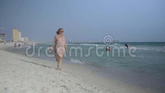 美丽的孕妇走在海边年轻的女人在等她的孩子抚摸着他的胃视频的预览图