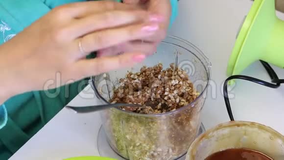 一个女人滚一个装满糖果的球把磨碎的花生和其他配料从搅拌机碗里混合为了制造视频的预览图